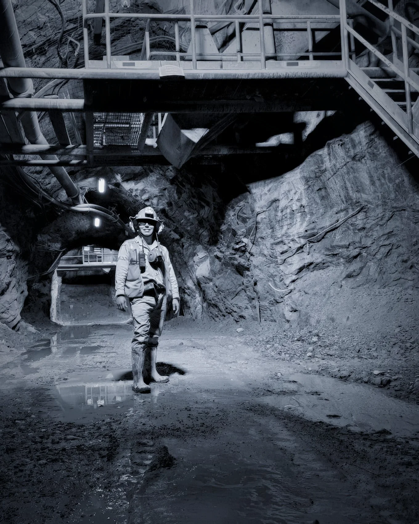 A miner walking out through a lit underground drift