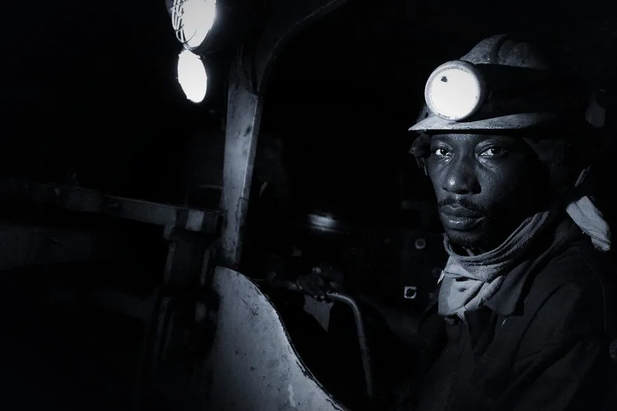 Miner underground lit by a cap lamp